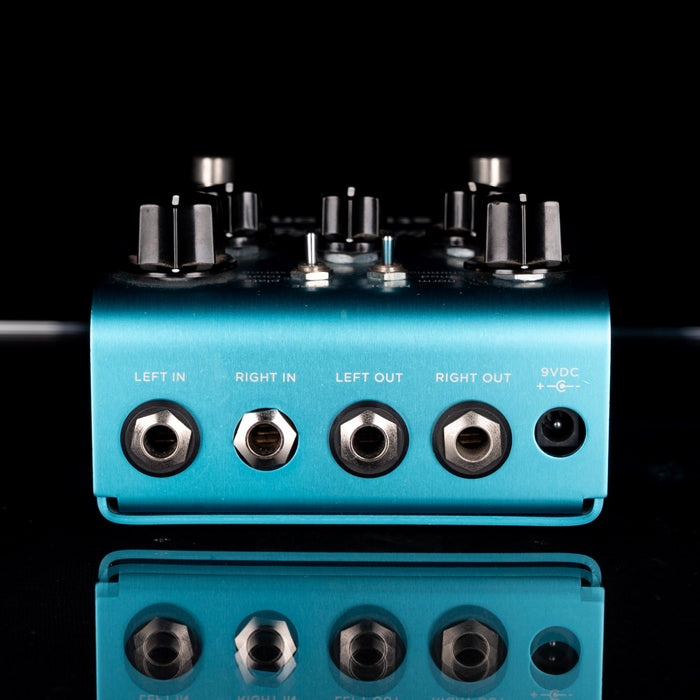 Blue audio interface with knobs and connectors on a black background