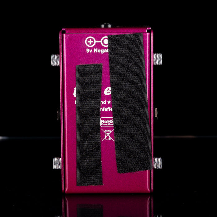 Purple electronic device with black straps on a black background