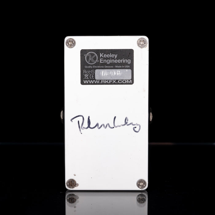 Keeley Engineering guitar effects pedal with a signature on a black background