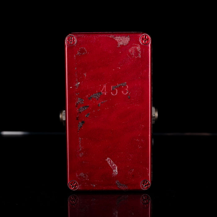 Red metal box with '453' engraving on a black background