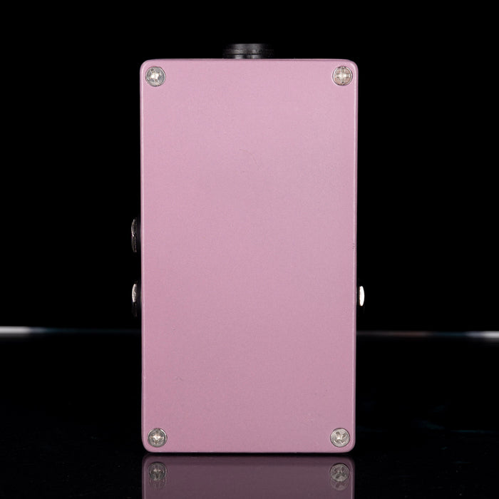 Pink electronic device with metallic screws on a black background