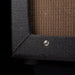 Close-up of a textured black speaker cabinet with a wooden panel.