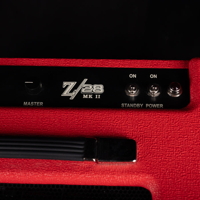 Close-up of a red amplifier with 'Zvex' branding on a black background