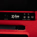 Close-up of a red amplifier with 'Zvex' branding on a black background