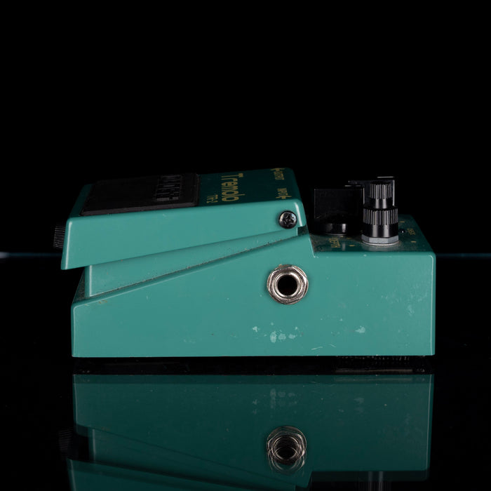 Teal guitar effects pedal on a black background