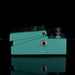 Teal guitar effects pedal on a black background