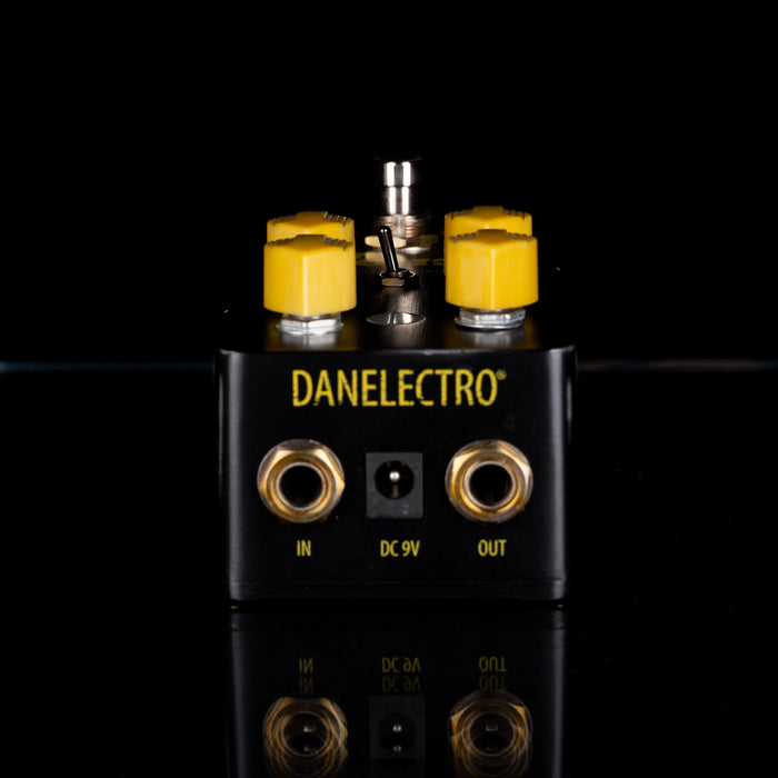 Danelectro guitar pedal with yellow knobs on a black background