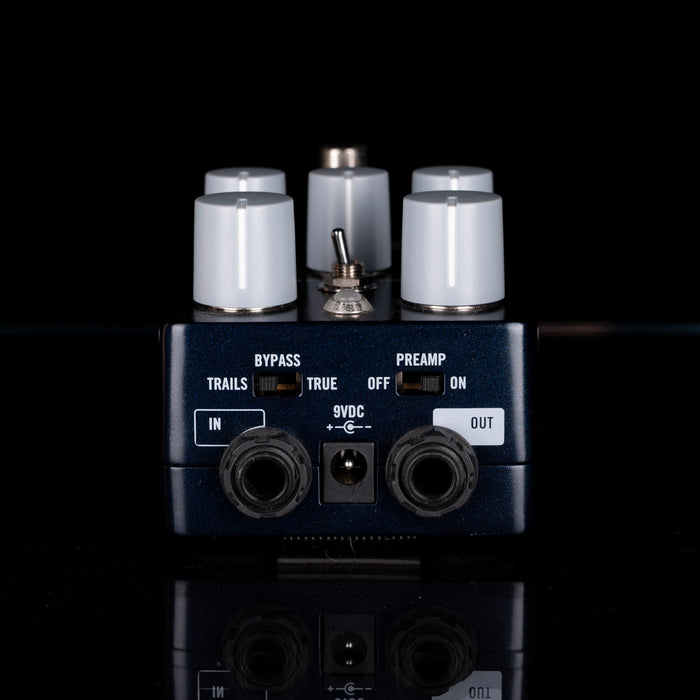 Guitar effects pedal with control knobs and input/output jacks on a black background