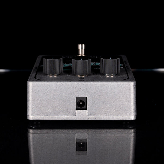 Electronic device with knobs on a reflective surface against a black background