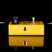 Yellow guitar effects pedal with black knobs on a black background