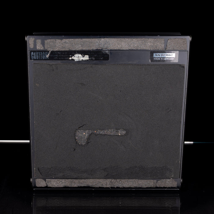 Black electronic device with visible wear and tear on a black background