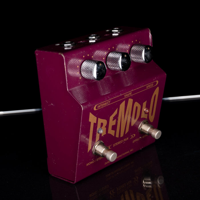 Purple guitar effects pedal with 'Tremolo' branding on a reflective surface.