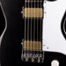 Close-up of a black electric guitar with white pickguard