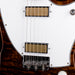 Close-up of a guitar's bridge and pickups with a white body and brown pickguard.
