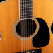 Close-up of an acoustic guitar with a focus on the soundhole and strings.