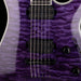 Close-up of a purple electric guitar with a focus on the neck and tuning pegs.
