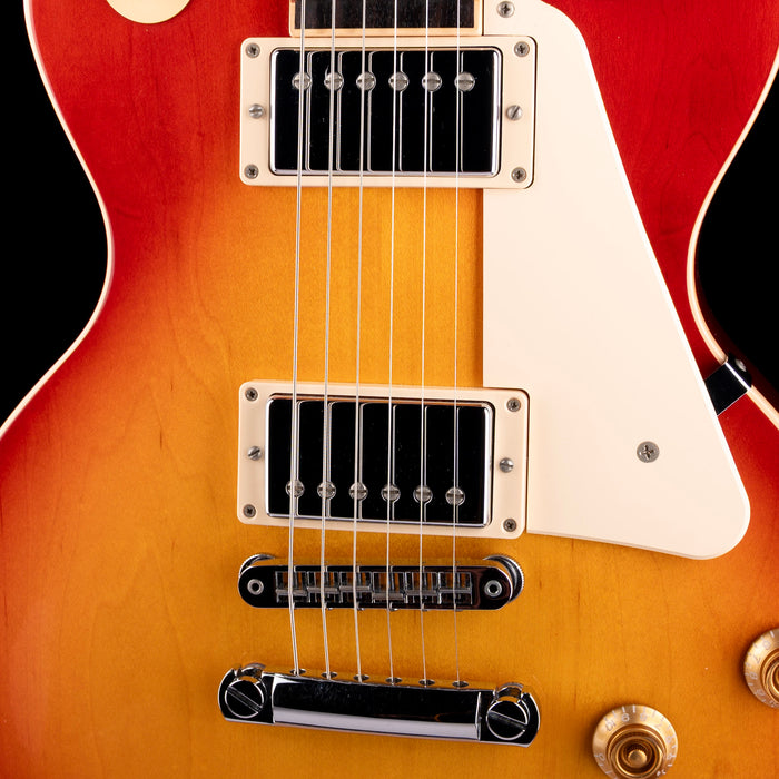 Close-up of a red electric guitar with a white pickguard