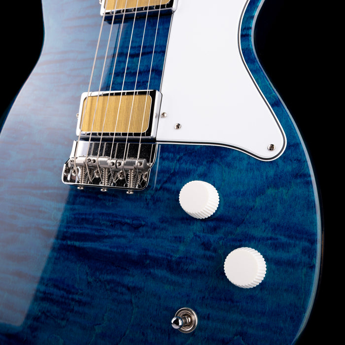 Close-up of a blue electric guitar with a black background