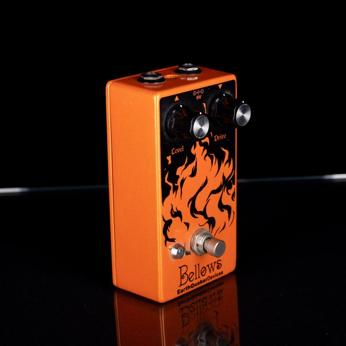 Orange guitar effects pedal with flame design on a black background