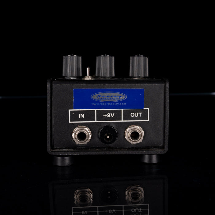 Black electronic device with input, output, and +9V connectors on a black background