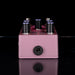 Pink guitar effects pedal with six knobs on a black background