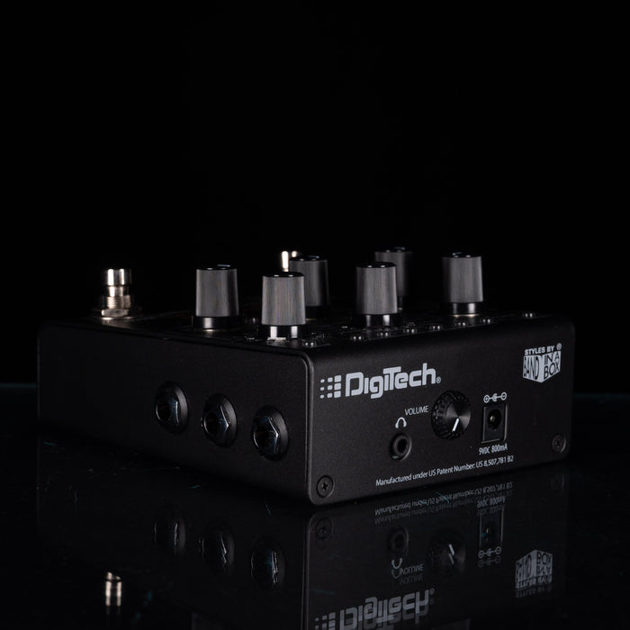 A black DigiTech audio effects pedal with multiple silver and black knobs, shown on a reflective black surface against a black background.