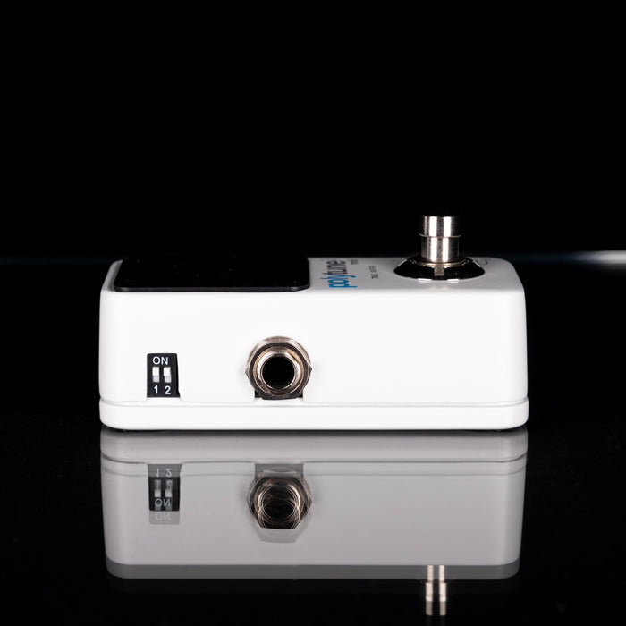 White guitar effects pedal with black background