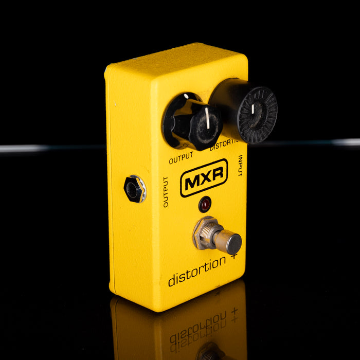 Yellow MXR distortion pedal on a black background