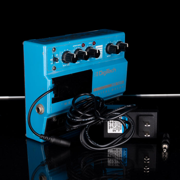 Blue electronic device with cables on a reflective black surface