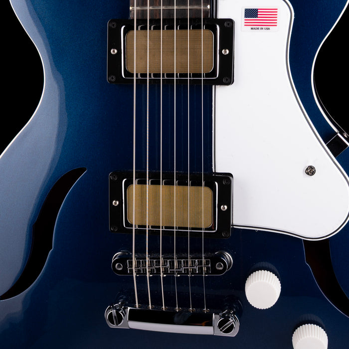 Close-up of a blue electric guitar with a white pickguard