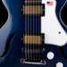 Close-up of a blue electric guitar with a white pickguard