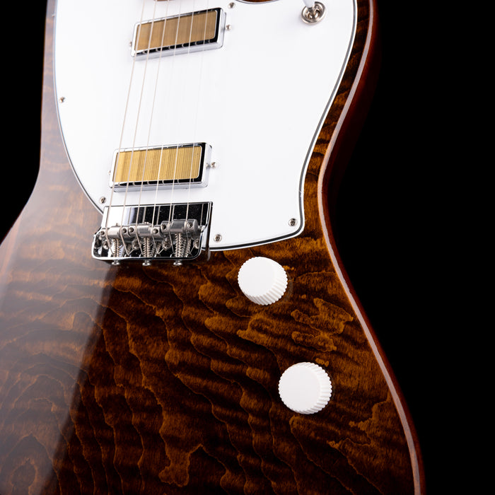 Close-up of a guitar with a focus on the neck and headstock against a black background