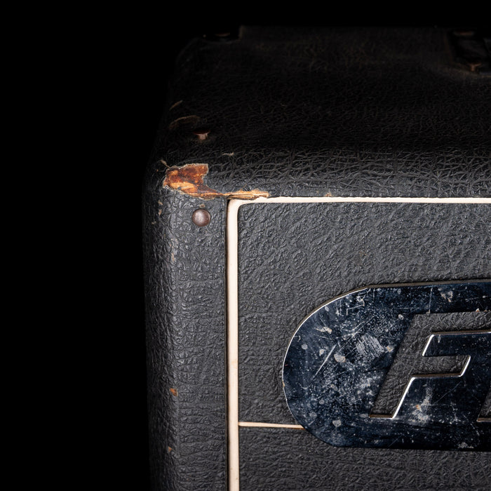 Close-up of a vintage amplifier with a brand logo on a black background