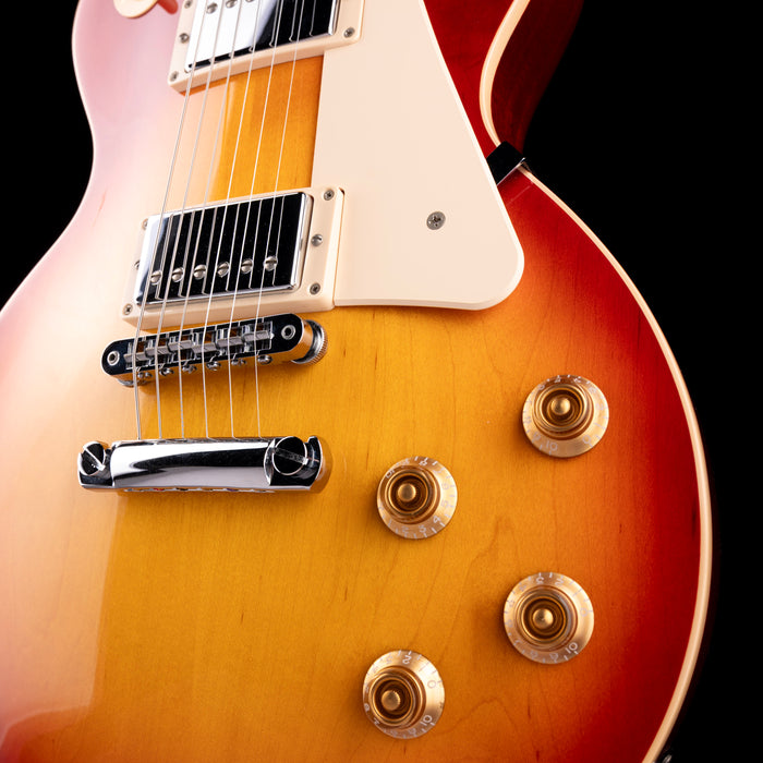Close-up of a Les Paul electric guitar with a sunburst finish on a black background