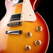 Close-up of a Les Paul electric guitar with a sunburst finish on a black background