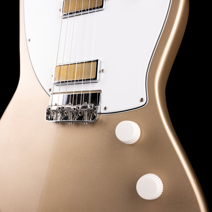 Close-up of a beige electric guitar with a black background