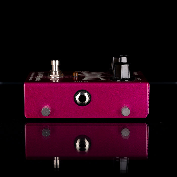 Purple guitar effects pedal with metallic components on a black background