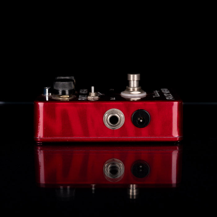 Red guitar effects pedal on a black background