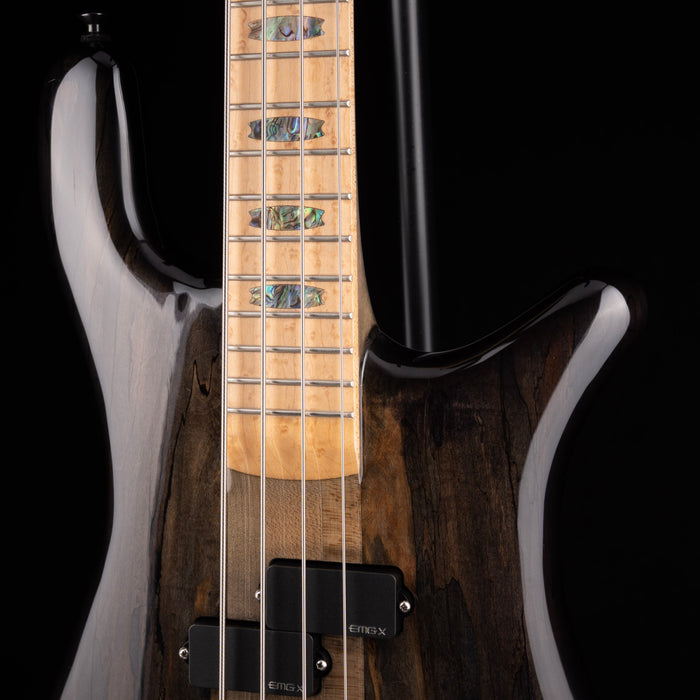 Close-up of a guitar with a focus on the neck and body against a black background