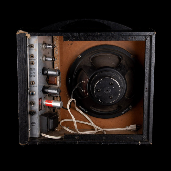 Vintage amplifier with speaker and control panel on a black background