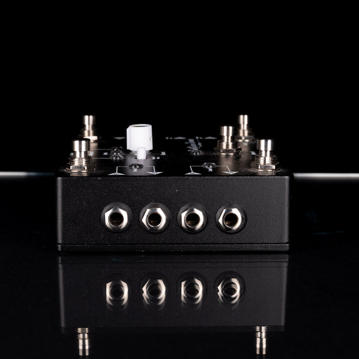 Black electronic device with multiple ports on a reflective surface and black background