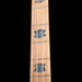 Close-up of a guitar neck with inlaid tortoiseshell patterns on a black background