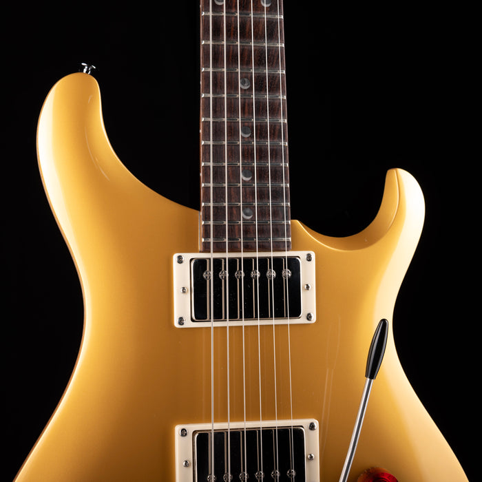 Gold electric guitar on a black background