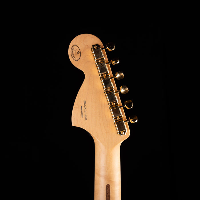 Guitar headstock with tuning pegs on a black background