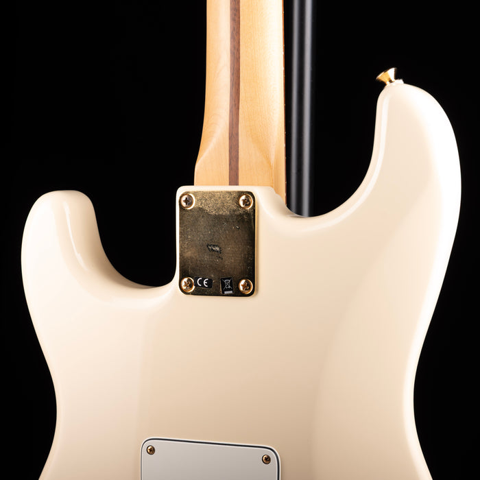 Close-up of a white electric guitar with a black background